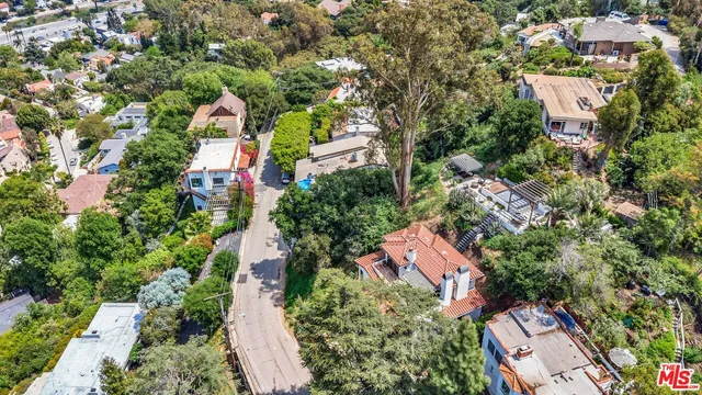 an aerial view of residential houses with outdoor space and trees all around
