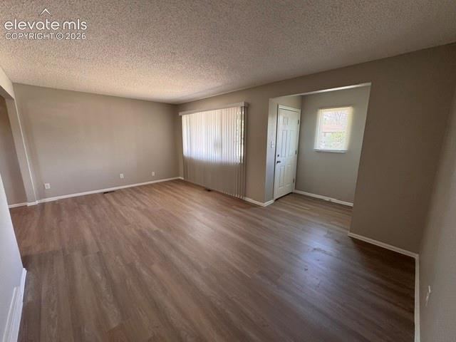 1922 Monterey Road Colorado Springs, CO 80910 - Photo 4 of 21 an empty room with wooden floor and windows