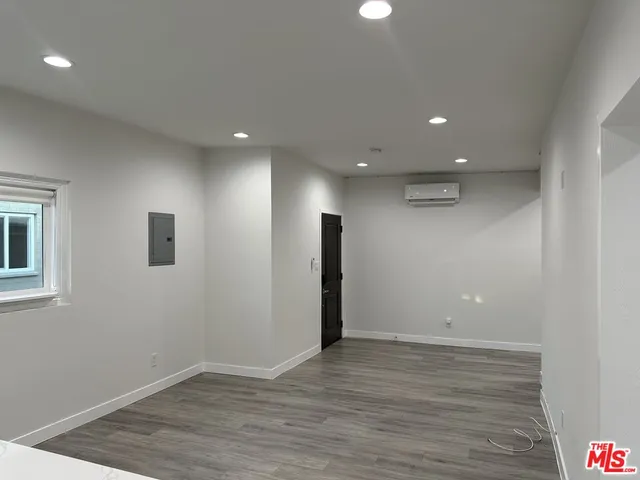 an empty room with wooden floor and entrance