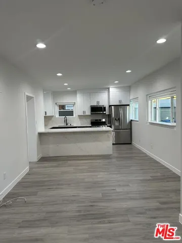 a view of kitchen with kitchen island stainless steel appliances refrigerator stove microwave and cabinets