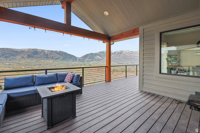 4527 North Seven Bridges Road Eden, UT 84310 - Photo 46 of 65 Wooden terrace with a mountain view and an outdoor living space with a fire pit