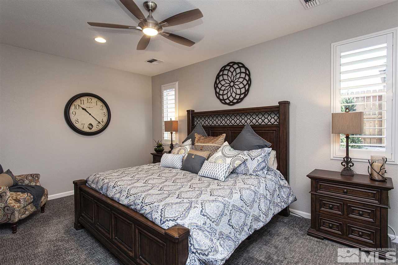 2190 Arpagos Lane Reno, NV 89521 - Photo 19 of 38 a bedroom with a bed and a chandelier