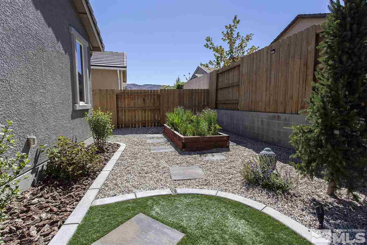 2190 Arpagos Lane Reno, NV 89521 - Photo 32 of 38 a view of a backyard with potted plants and a large tree