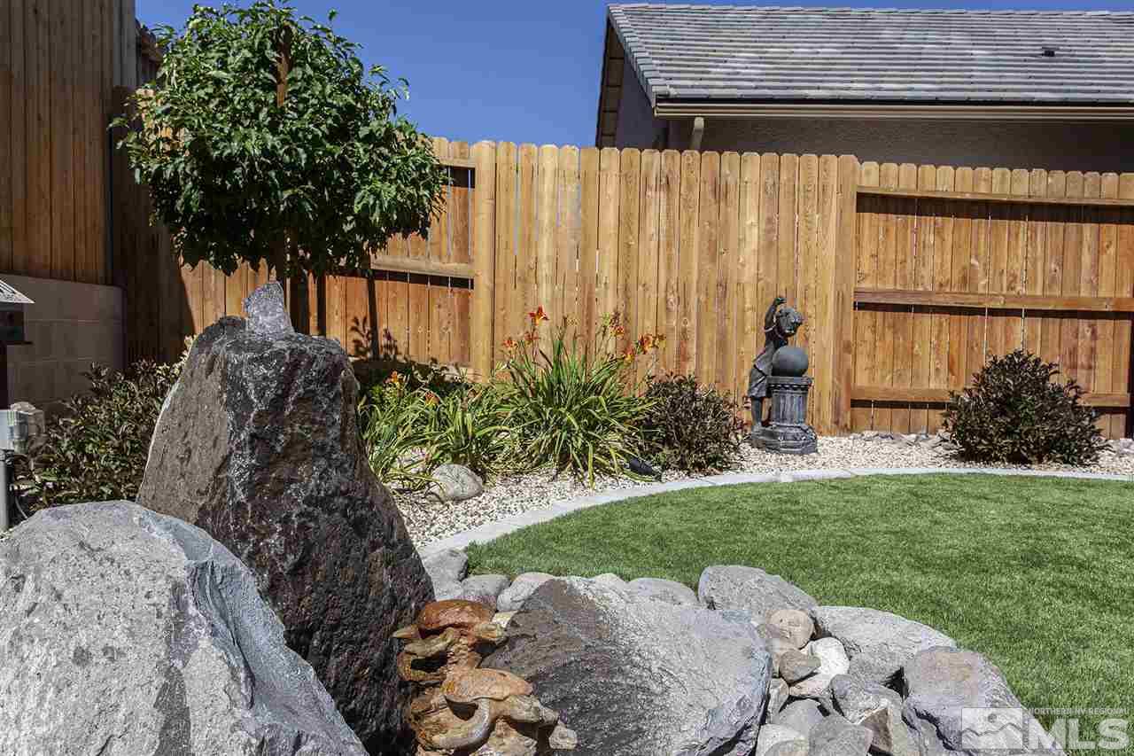 2190 Arpagos Lane Reno, NV 89521 - Photo 35 of 38 a view of a backyard with potted plants and a large tree