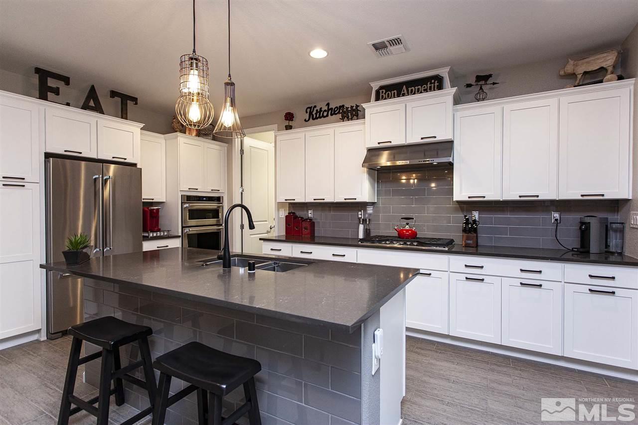 2190 Arpagos Lane Reno, NV 89521 - Photo 8 of 38 a kitchen with stainless steel appliances a sink a stove a refrigerator and cabinets