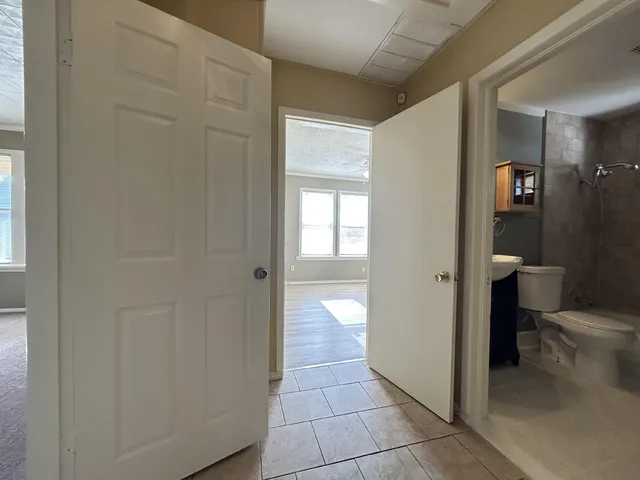 an empty room with windows and ceiling fan