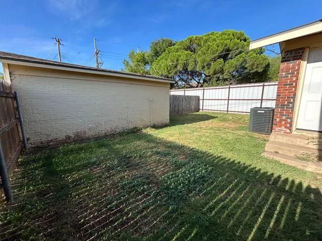 a view of a house with a big yard potted plants and large tree