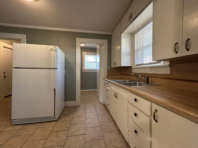a white refrigerator freezer and a stove sitting inside of a kitchen
