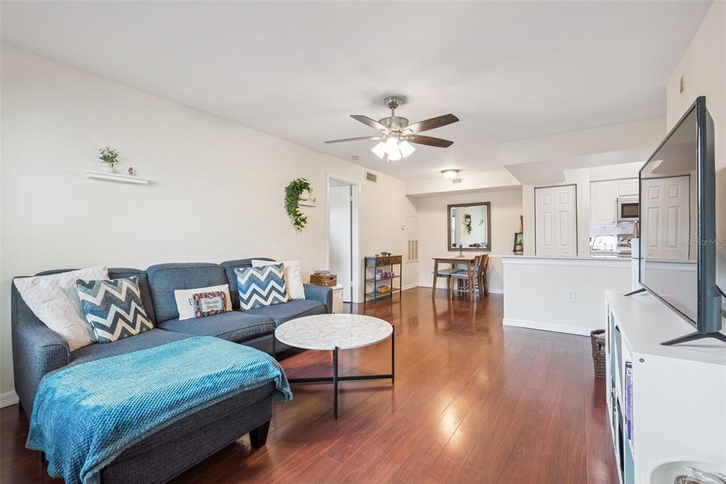 3032 Parkway Boulevard, Unit 305 Kissimmee, FL 34747 - Photo 3 of 40 a living room with furniture and a wooden floor