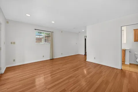 a view of empty room with wooden floor
