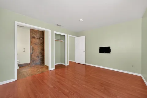 a view of an empty room with wooden floor
