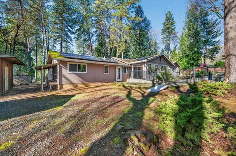 a view of a house with backyard and sitting area