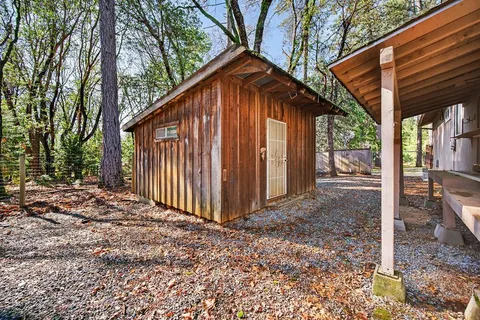 a view of a small house with backyard and trees
