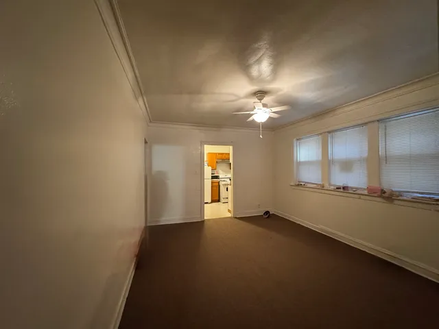 en empty room with windows and chandelier