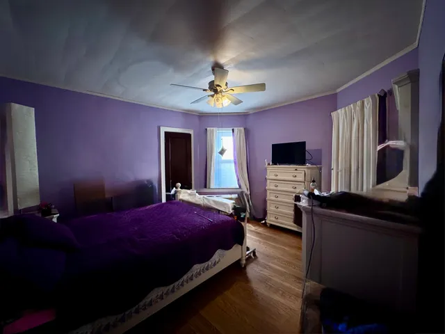 a bedroom with a bed and a flat tv screen on dresser