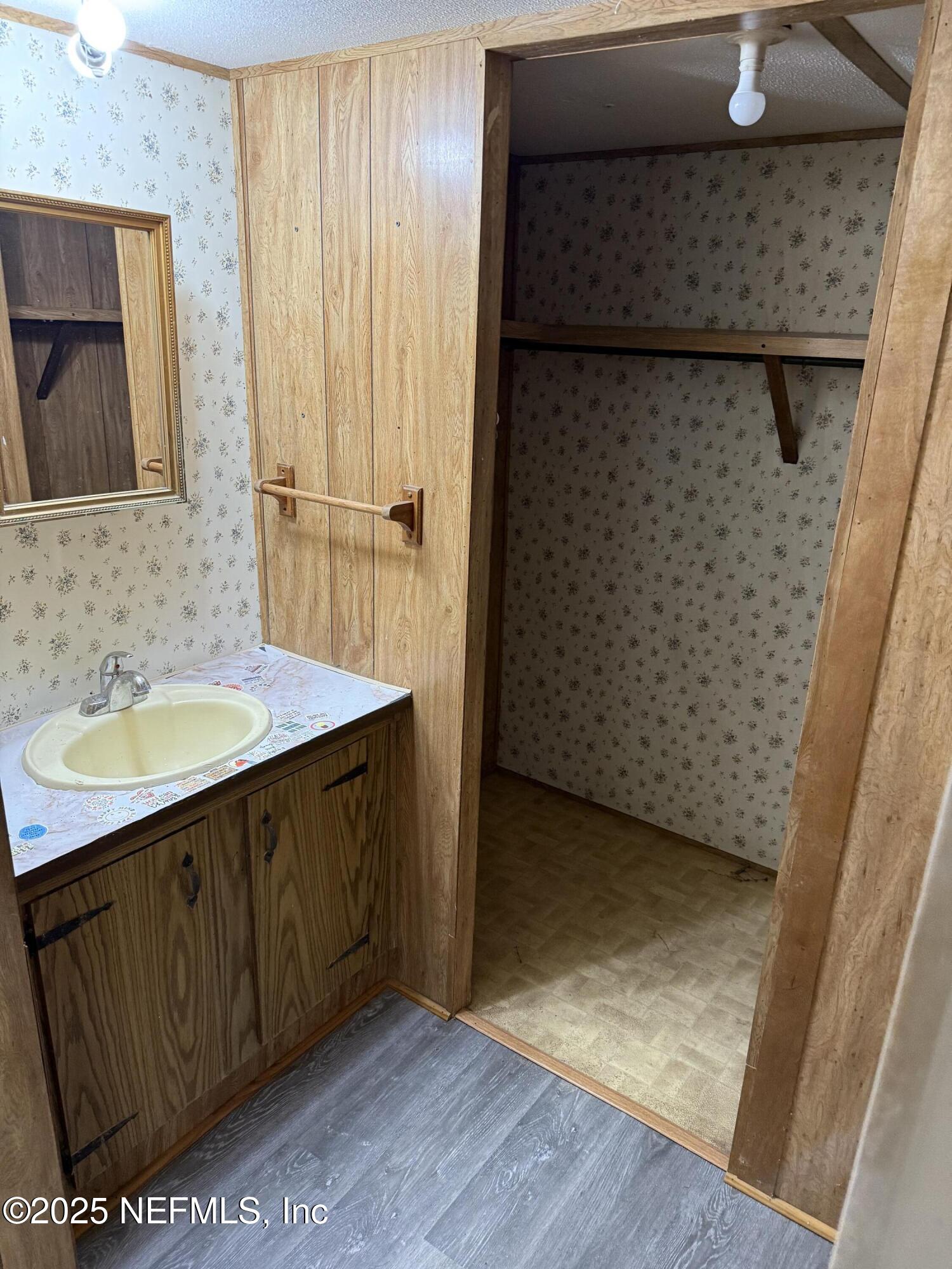 3255 County Road 208 St. Augustine, FL 32092 - Photo 19 of 22 a bathroom with a sink a mirror and shower