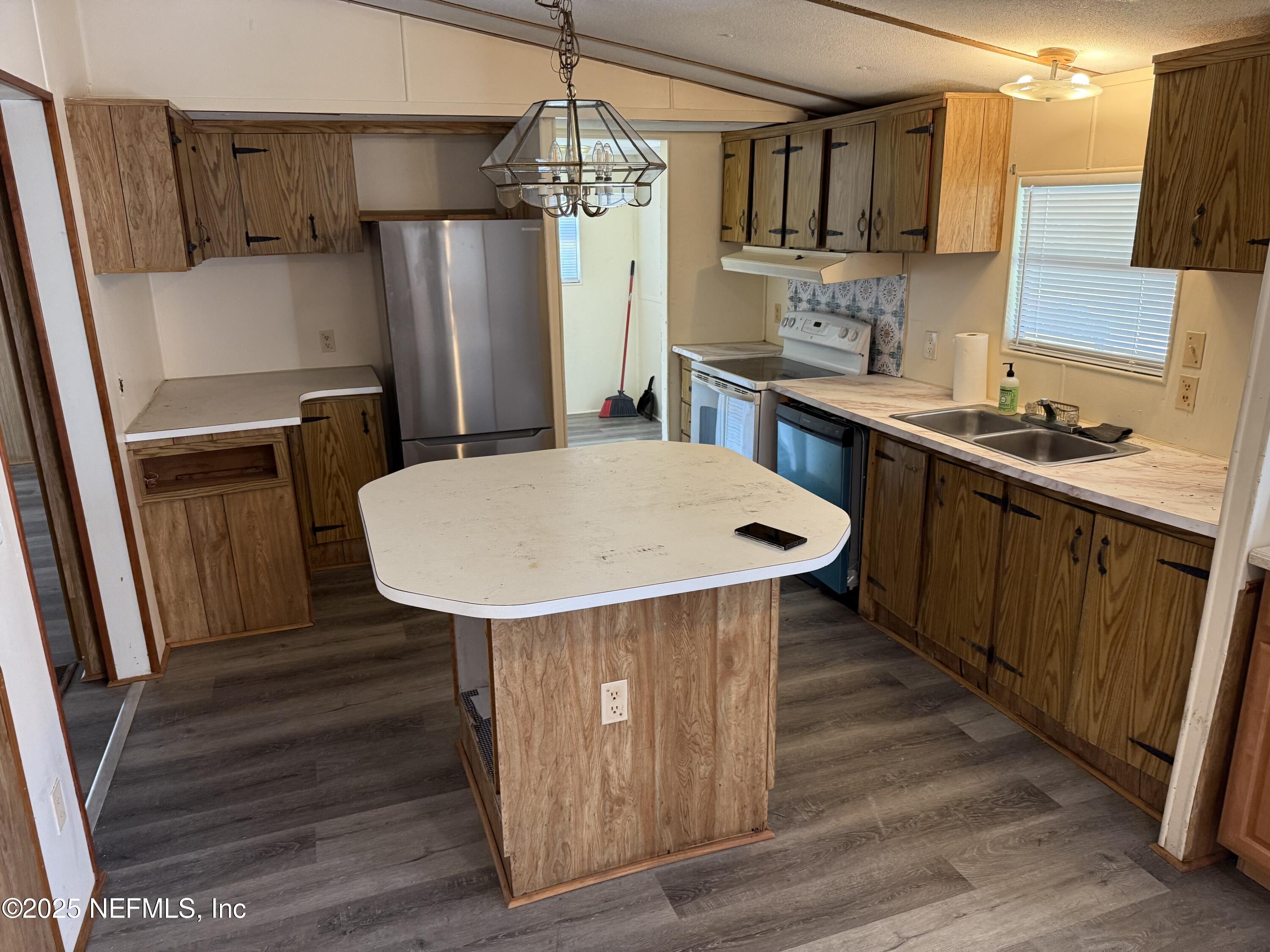 3255 County Road 208 St. Augustine, FL 32092 - Photo 8 of 22 a kitchen with stainless steel appliances a dining table chairs refrigerator and cabinets