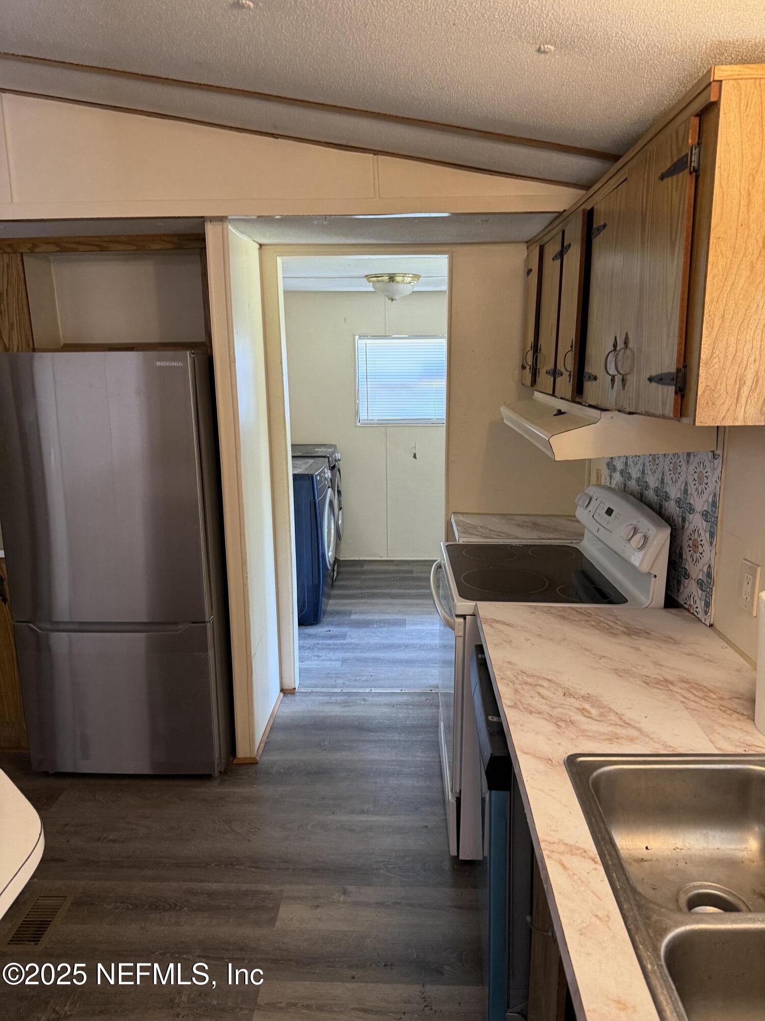3255 County Road 208 St. Augustine, FL 32092 - Photo 9 of 22 a kitchen with a refrigerator and a sink