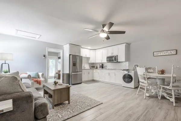 a living room with furniture a kitchen view and appliances