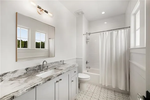 a bathroom with a granite countertop sink toilet and shower