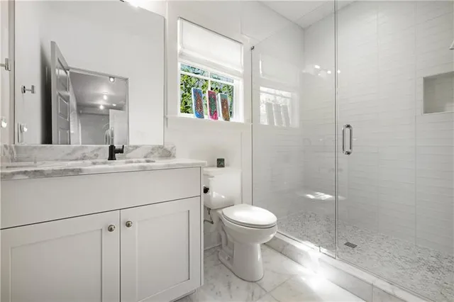 a bathroom with a sink toilet a mirror and shower