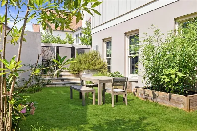 a view of a chair and table in backyard of the house