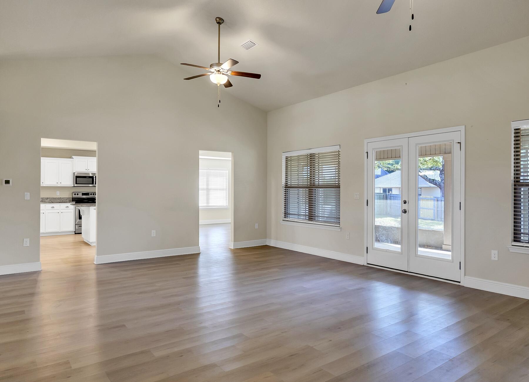3639 Ranch Drive Crestview, FL 32539 - Photo 45 of 84 a view of an empty room with wooden floor and a kitchen