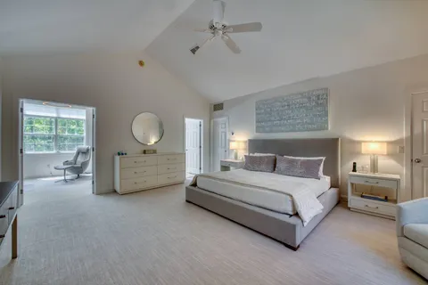 a spacious bedroom with a bed a couch and large window