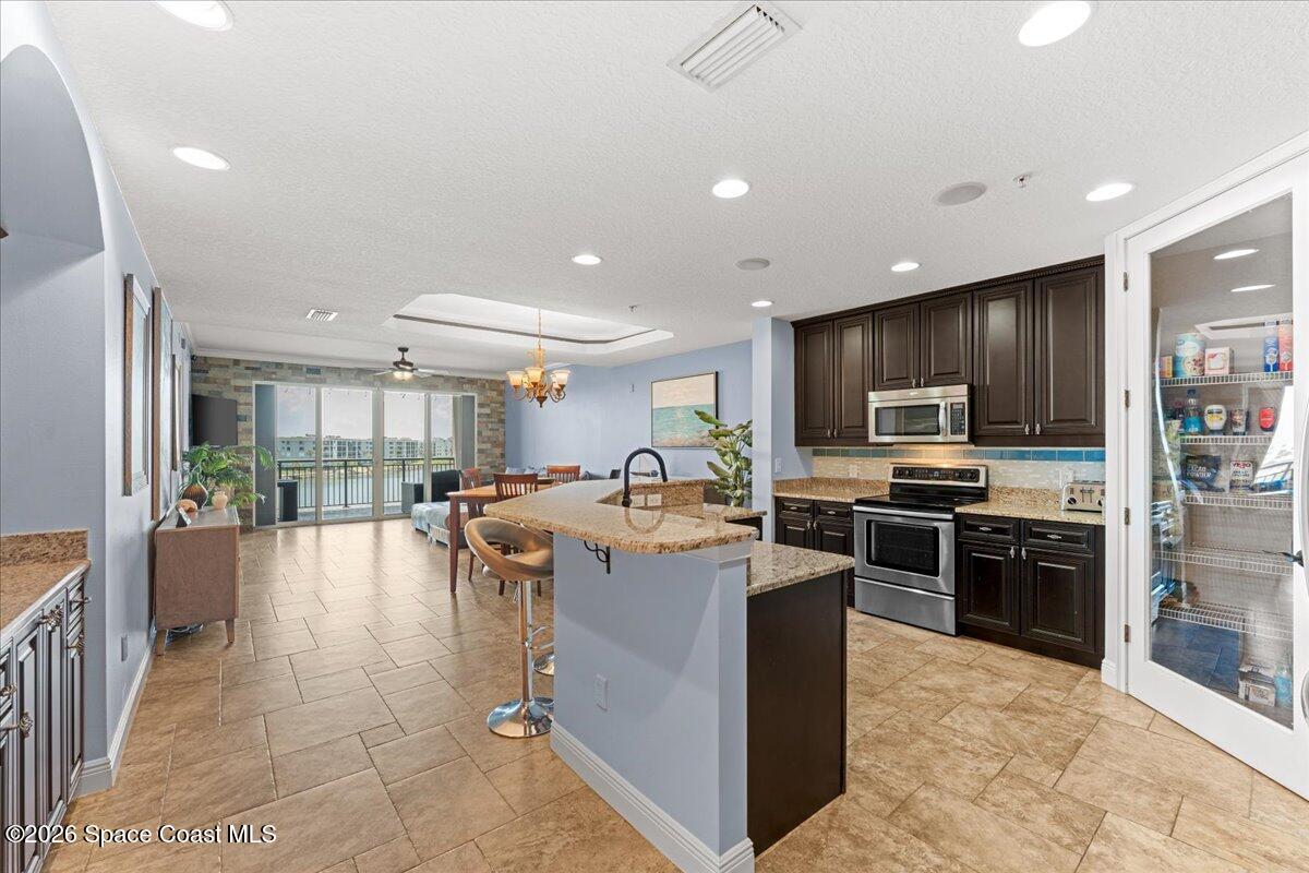 4125 West End Road, Unit 405 Cocoa Beach, FL 32931 - Photo 43 of 44 a large kitchen with stainless steel appliances lots of counter top space