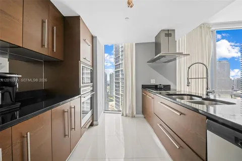 a kitchen with kitchen island a counter top space a sink stainless steel appliances and cabinets