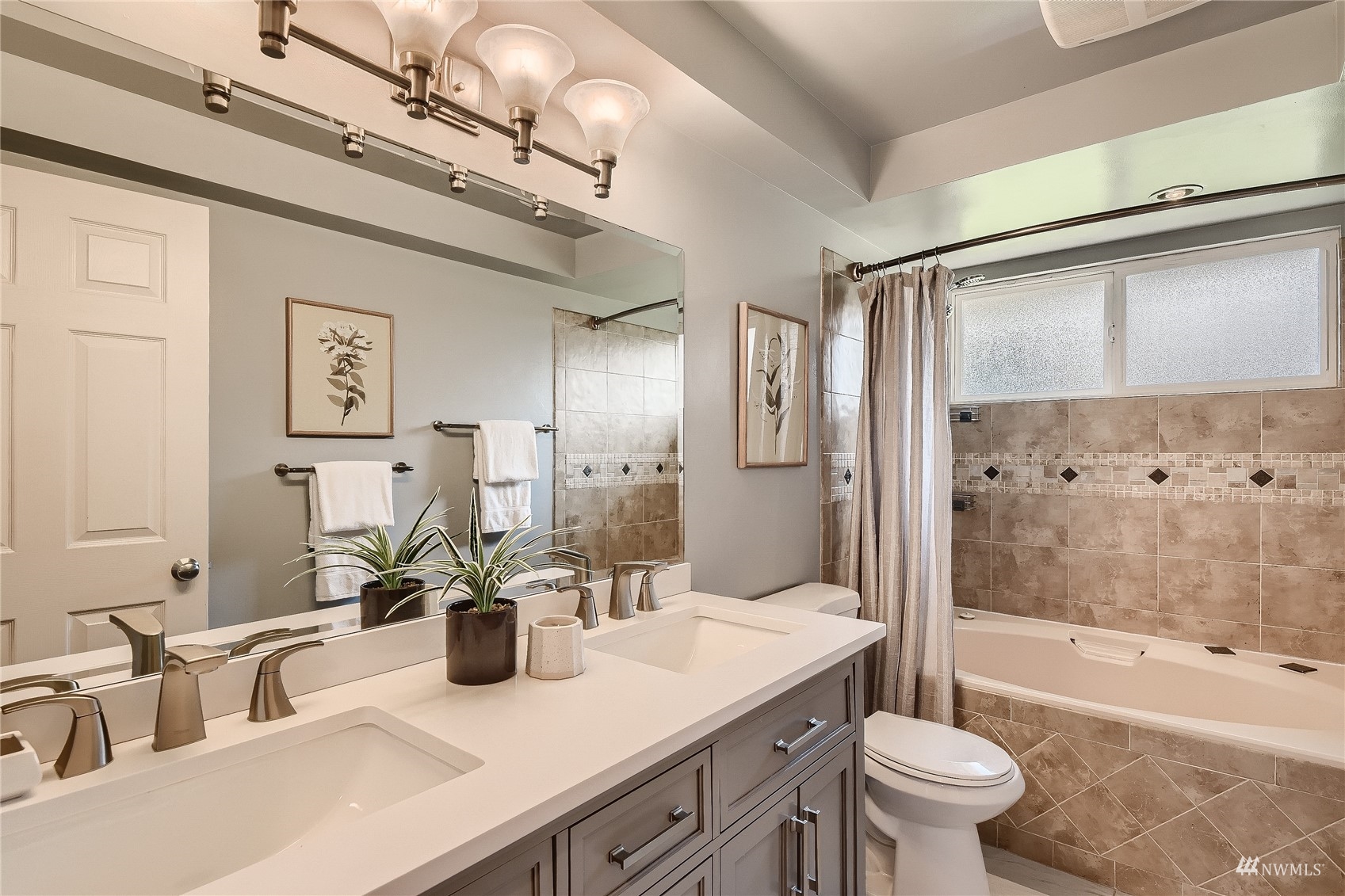 314 213th Place Southwest Bothell, WA 98021 - Photo 18 of 29 a bathroom with a granite countertop sink a toilet a mirror a vanity a bathtub and shower