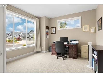a livingroom with workspace and a window