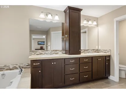 a bathroom with a granite countertop double vanity sink and mirror
