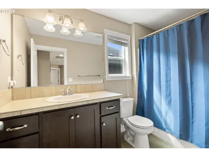a bathroom with a granite countertop sink toilet a mirror and a shower