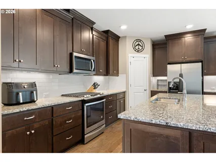 a kitchen with granite countertop stainless steel appliances and wooden cabinets