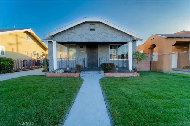 a front view of a house with a garden and plants