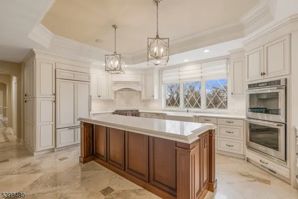 a kitchen with kitchen island granite countertop a stove a sink and a refrigerator