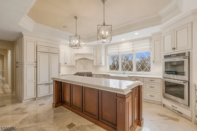 a kitchen with kitchen island granite countertop a stove a sink and a refrigerator