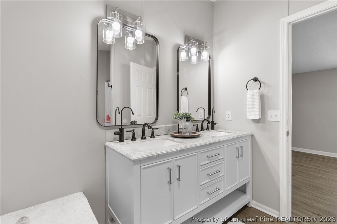 6568 Sandy Creek Road Stedman, NC 28391 - Photo 16 of 34 a bathroom with double vanity and a mirror