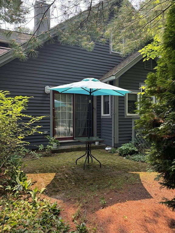 5 Amity Place, Unit 5 Amherst, MA 01002 - Photo 39 of 39 a porch with a table and chairs under an umbrella