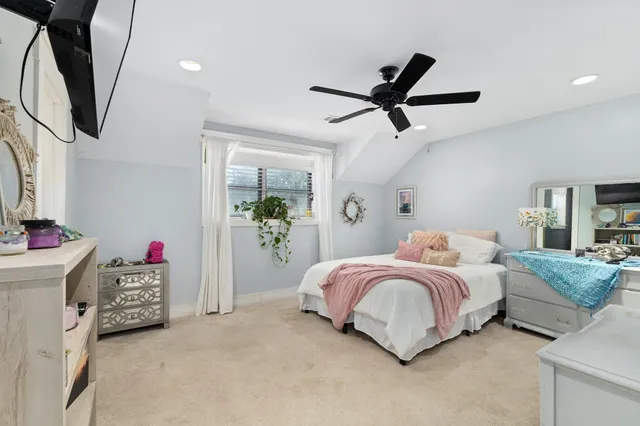 a bedroom with a bed a flat screen tv and dresser