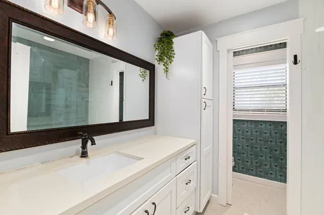 a bathroom with a sink a vanity and a mirror
