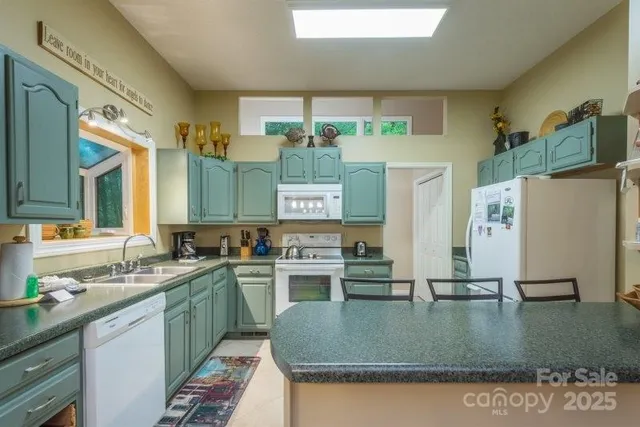 a kitchen with stainless steel appliances granite countertop a sink dishwasher and cabinets with wooden floor
