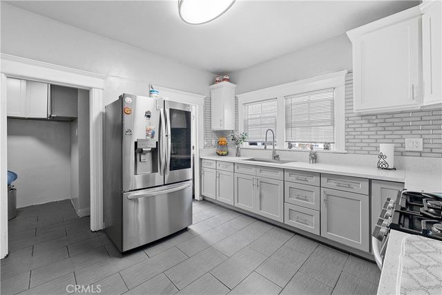 a kitchen with stainless steel appliances a refrigerator sink and cabinets