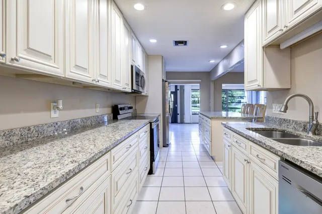 a kitchen with granite countertop a sink stove and cabinets