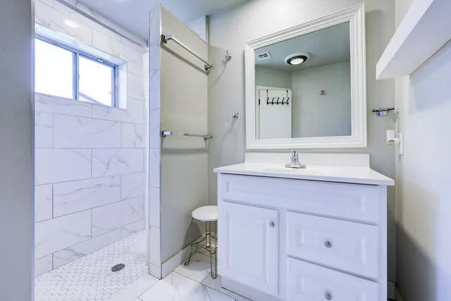 a bathroom with a sink a toilet and shower