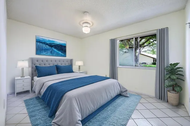 a bedroom with a large bed and a potted plant