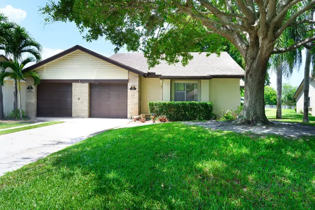 a view of a house with a yard and potted plants