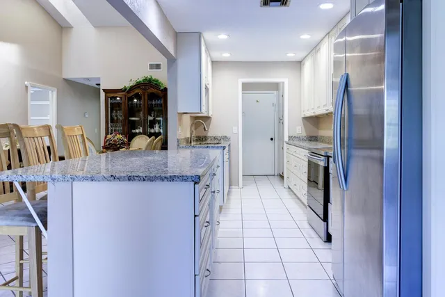 a kitchen with stainless steel appliances granite countertop a refrigerator and a sink
