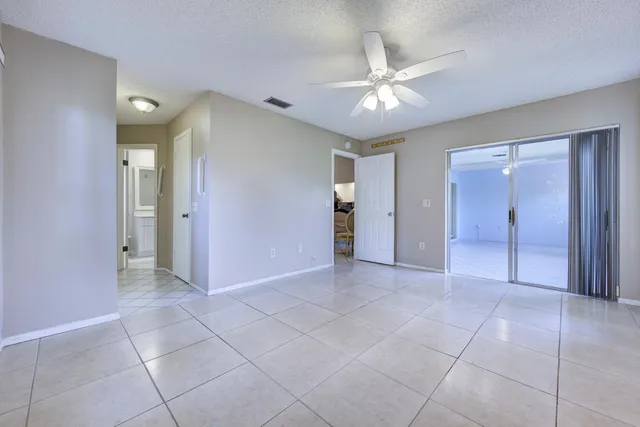 a view of a livingroom with a chandelier fan and windows